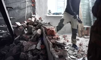 A man handyman breaks a brick wall with a hammer, builds and repairs house.